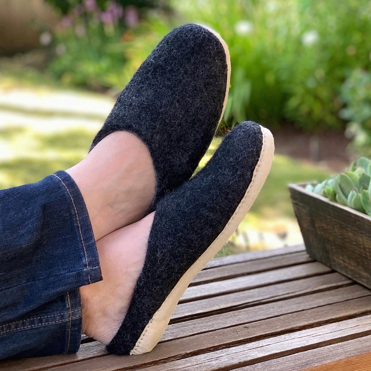 Man on bench wearing nootkas astoria slippers in charcoal